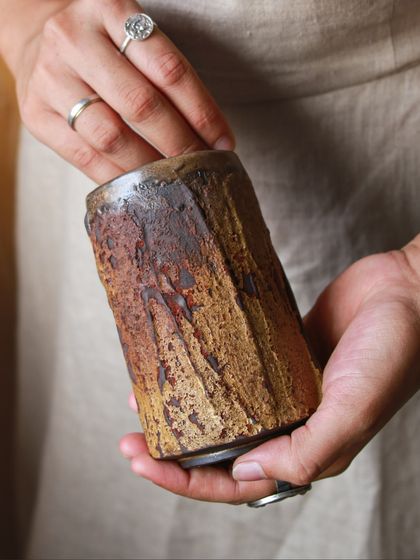 This tumbler carries the memory of its making. The textured surface is a result of exploring different slips, oxides, and firing atmospheres, creating a piece that invites you to pause and feel its journey.