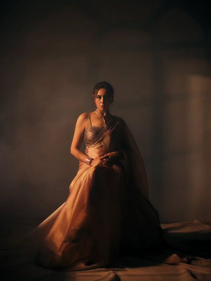 A wide shot that establishes a powerful, solitary mood. The single light source and expansive fabric create a dramatic silhouette, turning a simple portrait into a piece of visual art.