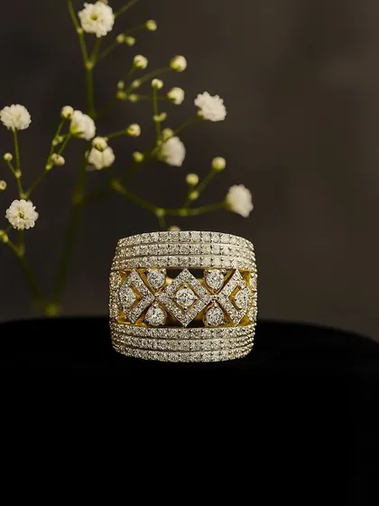 A product shot of the intricate statement diamond ring against a dark background, highlighting the geometric patterns and the sheer number of pavé-set diamonds.
