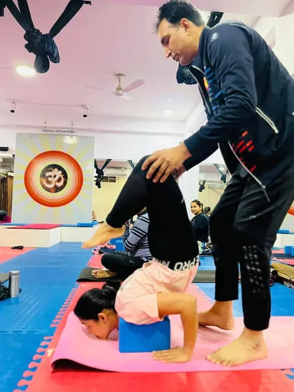 With my assistance, this young student is safely exploring an advanced inversion using a block for support. We believe in nurturing potential at every age.
