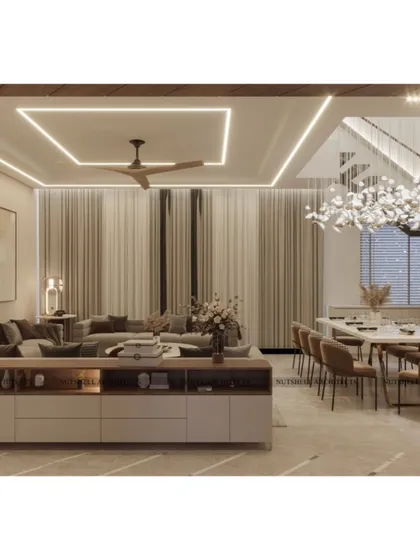 A wide view of the open-plan drawing and dining room. The space is unified by a consistent color palette, recessed ceiling lights, and a large, comfortable seating arrangement, making it ideal for hosting large gatherings.