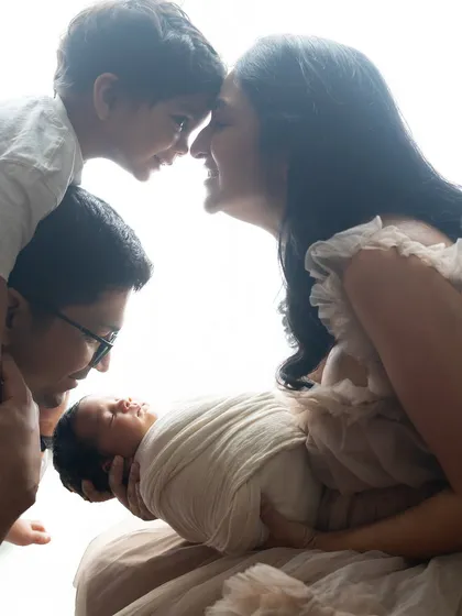A beautiful moment between siblings, with the older brother looking down at the newborn with so much love.