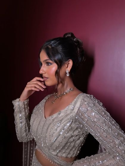 The profile view highlights the elegant updo and the beautifully sculpted cheekbones. This is a complete head-to-toe glam look, perfect for a reception.