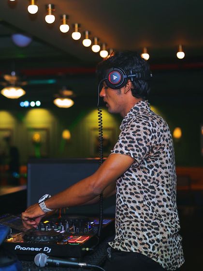 Focused on the mix, with my headphones on, ensuring every transition is perfect.