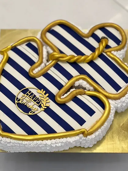 An anchor-themed cake with a nautical blue and white stripe pattern. The golden rope detail adds a touch of class. This is a great custom design for someone who loves the sea.