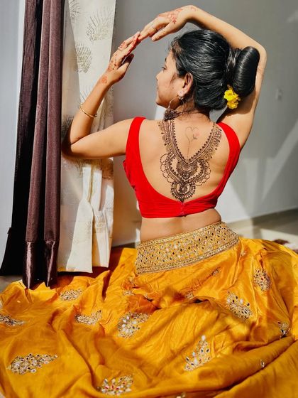 Another pose showing the graceful back mehndi design. The client is also wearing a small heart tattoo, which we incorporated into the overall look.