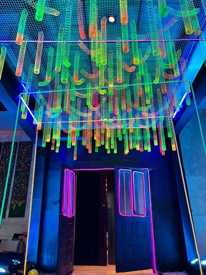 The vibrant entrance to a neon-themed party for Round Table India. We created a ceiling installation using hundreds of colorful, glowing slinky toys to produce a playful and energetic welcome for guests.