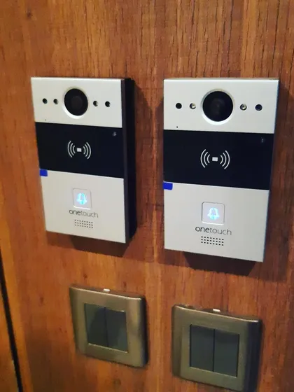 Here is an installation of two OneTouch video entry units on a wooden panel. This setup provides secure, app-based access control, allowing residents to see and speak with visitors before granting entry, all from their mobile phones.