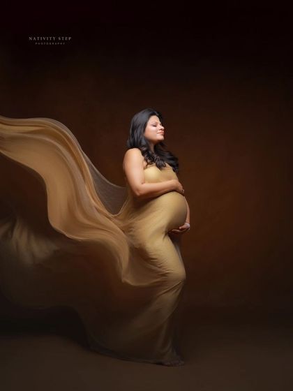 A profile shot capturing the beautiful movement of a golden gown. The focus is on the elegant silhouette and the texture of the fabric.
