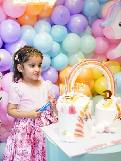 The birthday girl gets ready to blow out the candles on her incredible double unicorn cake.