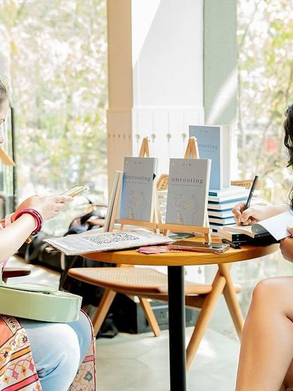 Two attendees getting their books signed simultaneously, showing the high level of engagement at our events.