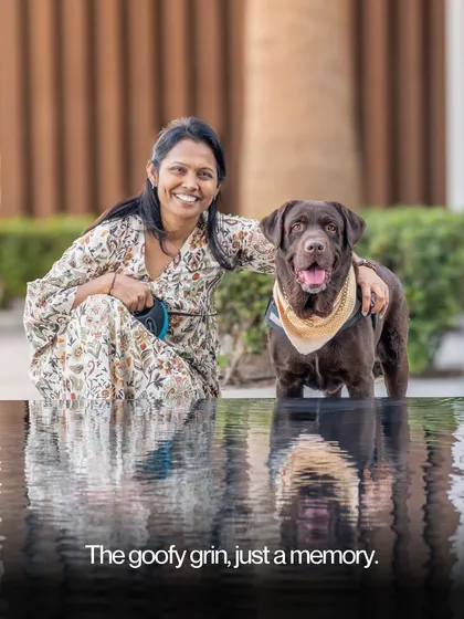A beautiful portrait of a woman and her chocolate lab enjoying a moment by the water, their reflections adding a touch of magic to the scene.