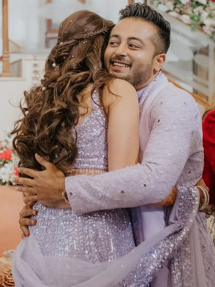A sweet moment captured on camera. The bride's hair looks stunning from the back, with the soft curls and pearl details.