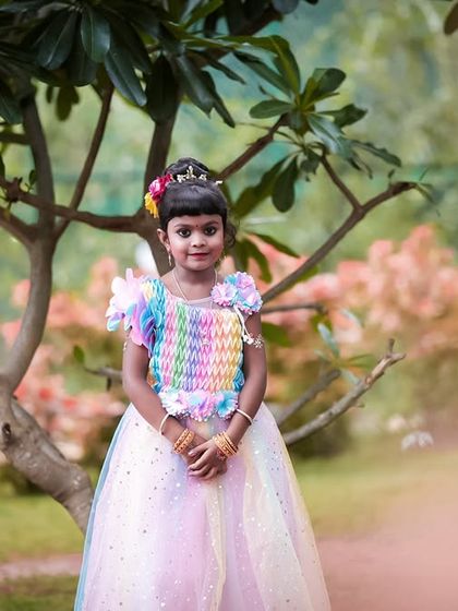A beautiful outdoor portrait of the birthday girl in her rainbow dress. The natural light and setting create a soft, timeless feel.