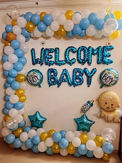A classic "Welcome Baby" wall decoration for a boy. The blue, white, and gold balloon frame surrounds the foil letters, creating a festive and happy vibe.