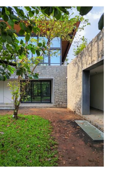 The 'House in a Grove' under construction, showing the relationship between the built form and the surrounding earth and trees.