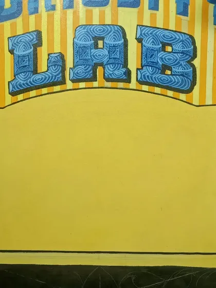 The "Curiosity Lab" sign during its creation, with the patterned lettering finished and the central space ready for more design elements.