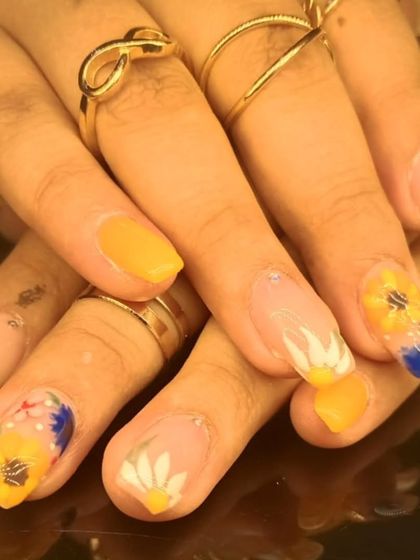 A bright and cheerful summer manicure with hand-painted sunflowers and daisies.