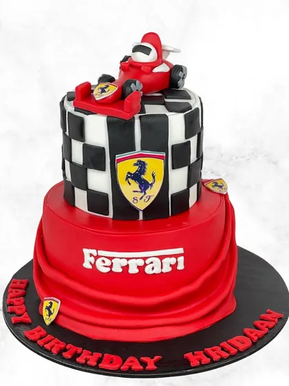 Zooming into Hridaan's birthday with this awesome Ferrari-themed cake. The two-tier design features the iconic red, a checkered flag pattern, and a race car topper.