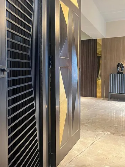 The entrance to the Juhu residence makes a statement with a custom-designed door featuring geometric brass inlays. It sets the tone for the luxurious and artfully designed interiors that lie within.