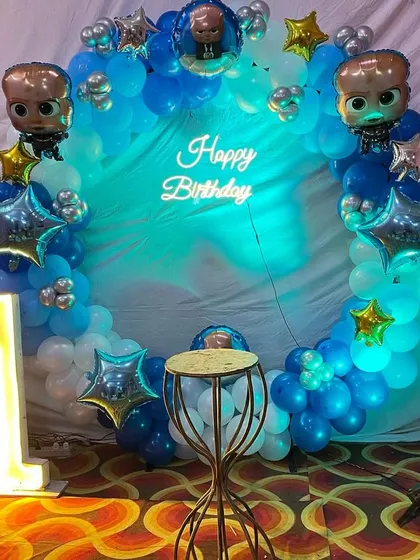 A close-up of the Boss Baby ring backdrop with a 'Happy Birthday' neon sign.