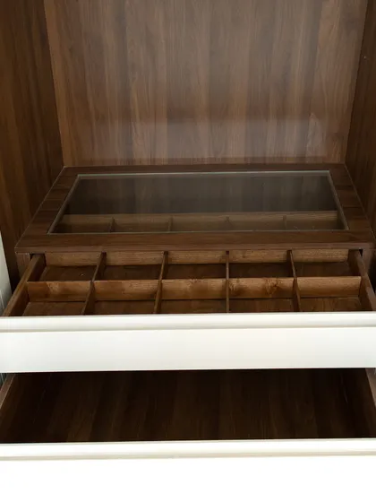 An accessory drawer with a glass top and custom compartments is the perfect way to organize and display your watches, jewelry, and other valuables.