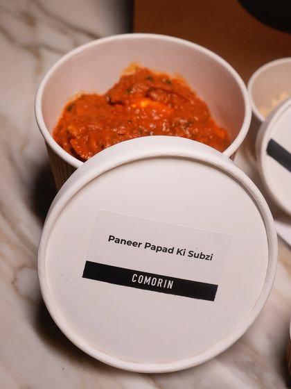 A close-up of our Paneer Papad Ki Sabzi, labeled and sealed for freshness. We ensure every component of your meal is clearly marked for an easy and enjoyable dining experience at home.