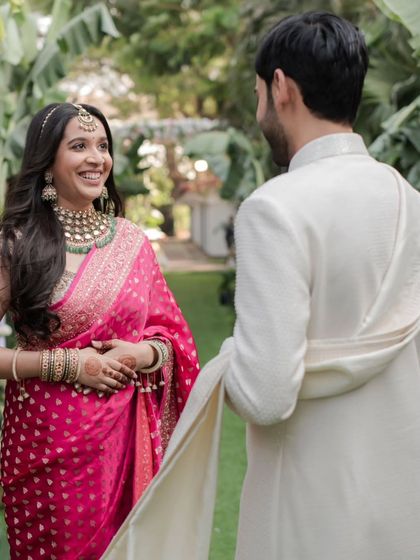 The bride's genuine smile as she sees her groom for the first time on their wedding day, a priceless 'first look' moment.