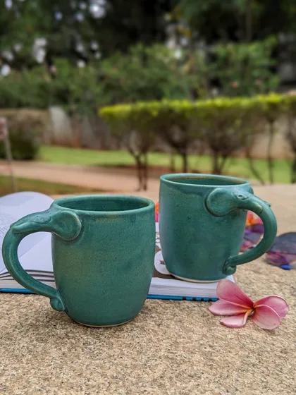 Here are my beloved Periyar elephant mugs, captured during a quiet moment outdoors. Handcrafted by studio potters, the handle is shaped like a trunk, making each sip a delightful experience. They are a perfect example of how I blend unique design with everyday use.