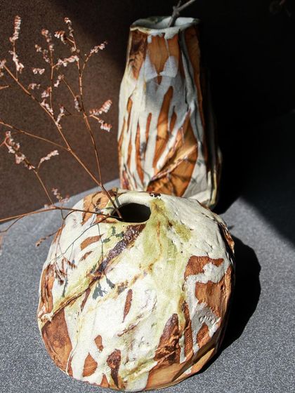 Two Kurinuki vases, one tall and one round, displayed together to showcase their shared rustic aesthetic and unique individual characters.