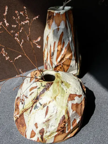 Another view of the two Kurinuki vases, showcasing their unique personalities. One is rugged and earthy, the other more refined and sculptural.