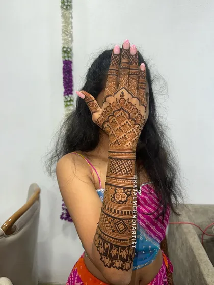 A bridesmaid posing with her full arm henna design.