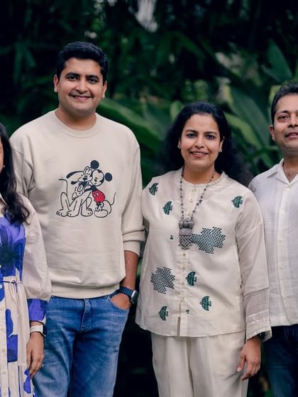 A classic group photo of four family members, posed comfortably in an outdoor setting. This is a timeless way to document your family.