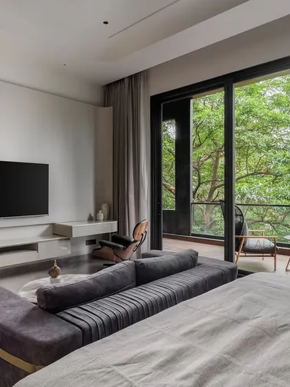 This master bedroom is a quiet getaway within the home. The floating TV console and minimalist design keep the space feeling open, while the large sliding doors offer a constant connection to the green outdoors.