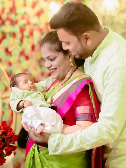 A bright and happy family portrait. The parents' proud smiles and the baby's curious gaze make for a perfect family photo.