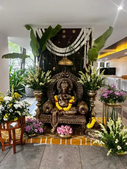 A majestic Ganesha idol setup to welcome guests and bless the occasion, adorned with fresh flowers and banana leaves.