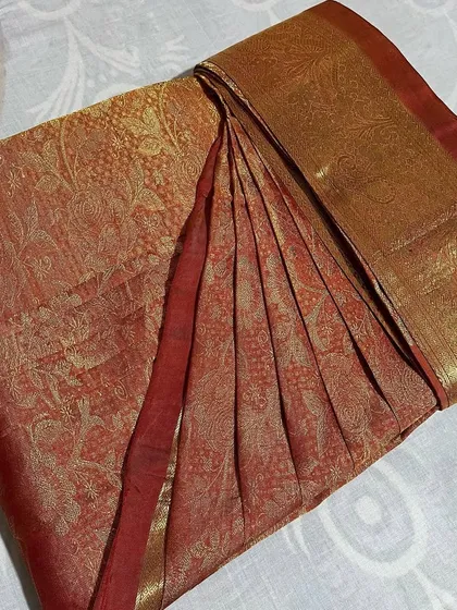 A rustic red and gold saree, showcasing the beauty of traditional weaves.