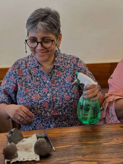Laughter is a key ingredient in my workshops. Here, a participant enjoys a lighthearted moment while working on her ceramic sculpture.