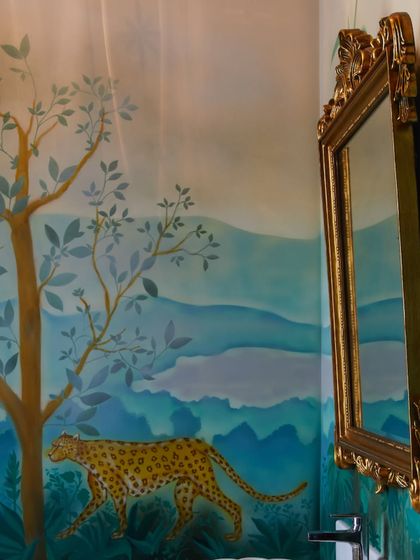 The hand-painted cheetah mural in this powder room is a perfect example of art-infused design. The soft, layered landscape creates a sense of depth and whimsy, turning a small, functional space into an unforgettable experience.