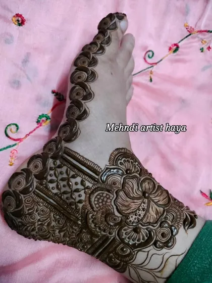 An intricate foot design with the fresh paste on, showing the beautiful combination of floral, paisley, and geometric patterns.