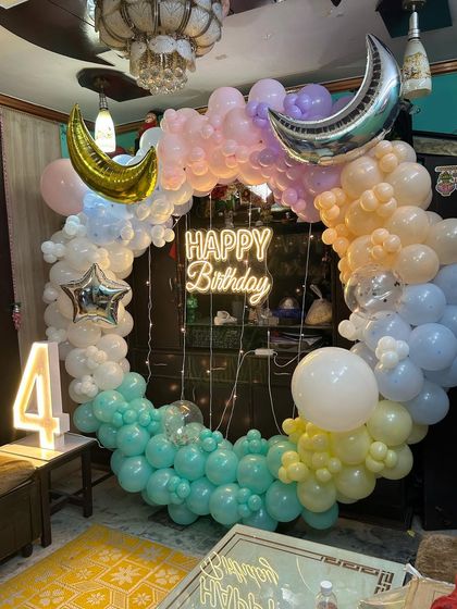 A dreamy 4th birthday ring in pastel colors with moon and star foil balloons and a light-up number.
