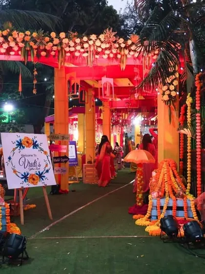 As day turns to night, the same Haldi entrance is illuminated with spotlights and fairy lights. This ensures the festive and welcoming vibe continues, guiding guests into the celebration space with a warm glow.