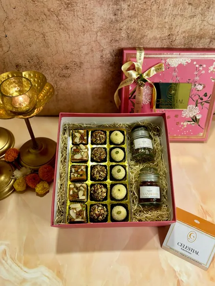 A top-down view of the 'Bliss Box', showing the intricate details of the roasted almond truffles, coconut ladoos, and rose pistachio shortbread.