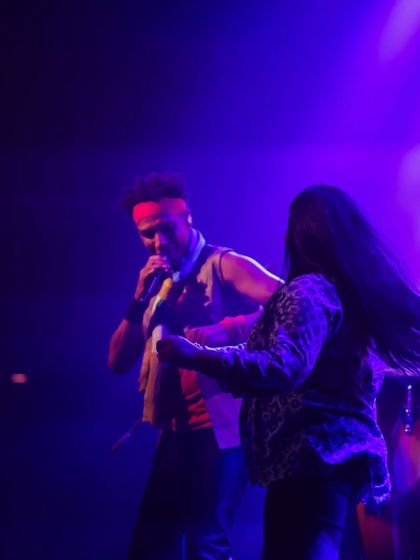 David Walters invites an audience member to dance on stage with him. This moment of spontaneous interaction highlights the fun and inclusive atmosphere of our concerts.