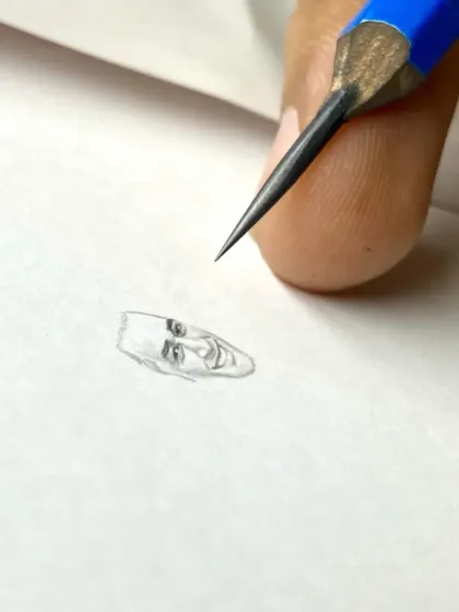 The very beginning of the miniature sketch, starting with just the outline of MS Dhoni's face.