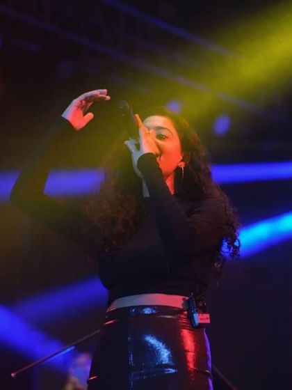 A female artist singing her heart out under colorful stage lights. College fests are a platform for diverse talents, and I make sure to capture them all.