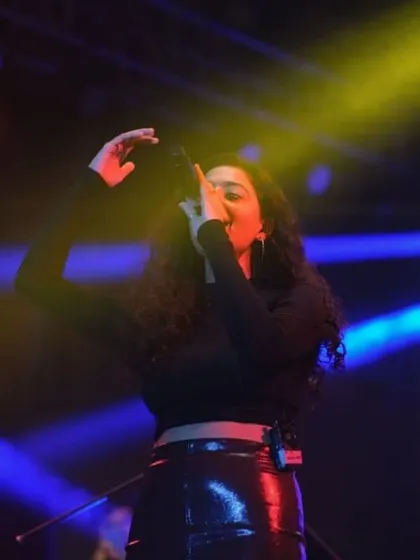 A female artist singing her heart out under colorful stage lights. College fests are a platform for diverse talents, and I make sure to capture them all.