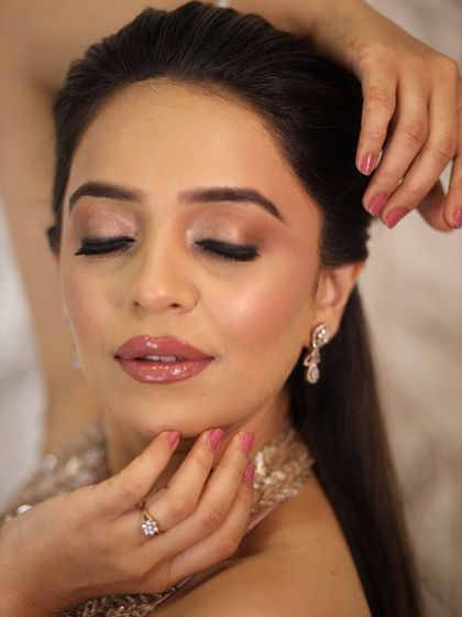 A close-up of the eye and lip details. The pink-toned shimmer and glossy nude lips are a perfect combination for a soft and romantic look.