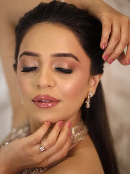 A close-up of the eye and lip details. The pink-toned shimmer and glossy nude lips are a perfect combination for a soft and romantic look.