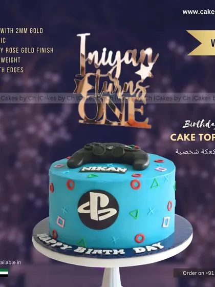 A mockup of the "Iniyan Turns ONE" topper on a PlayStation-themed cake, showing how toppers can be customized for specific interests.